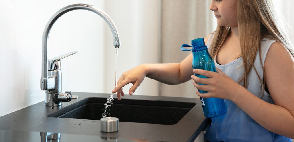 Tyttö ja vesipullo.